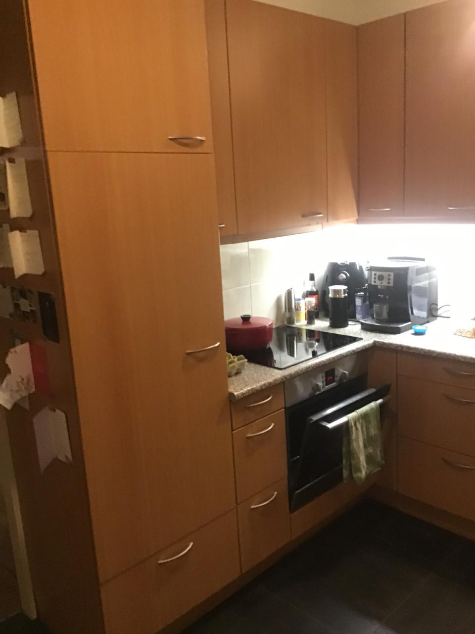 Doorleefde grenen vloer en keuken met koelkast/oven/kookplaat