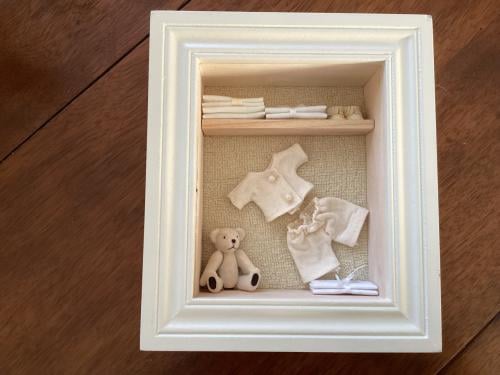 2 houten kastjes met schelpen en baby-tafereeltje.