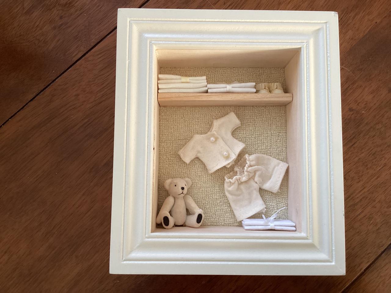 2 houten kastjes met schelpen en baby-tafereeltje.