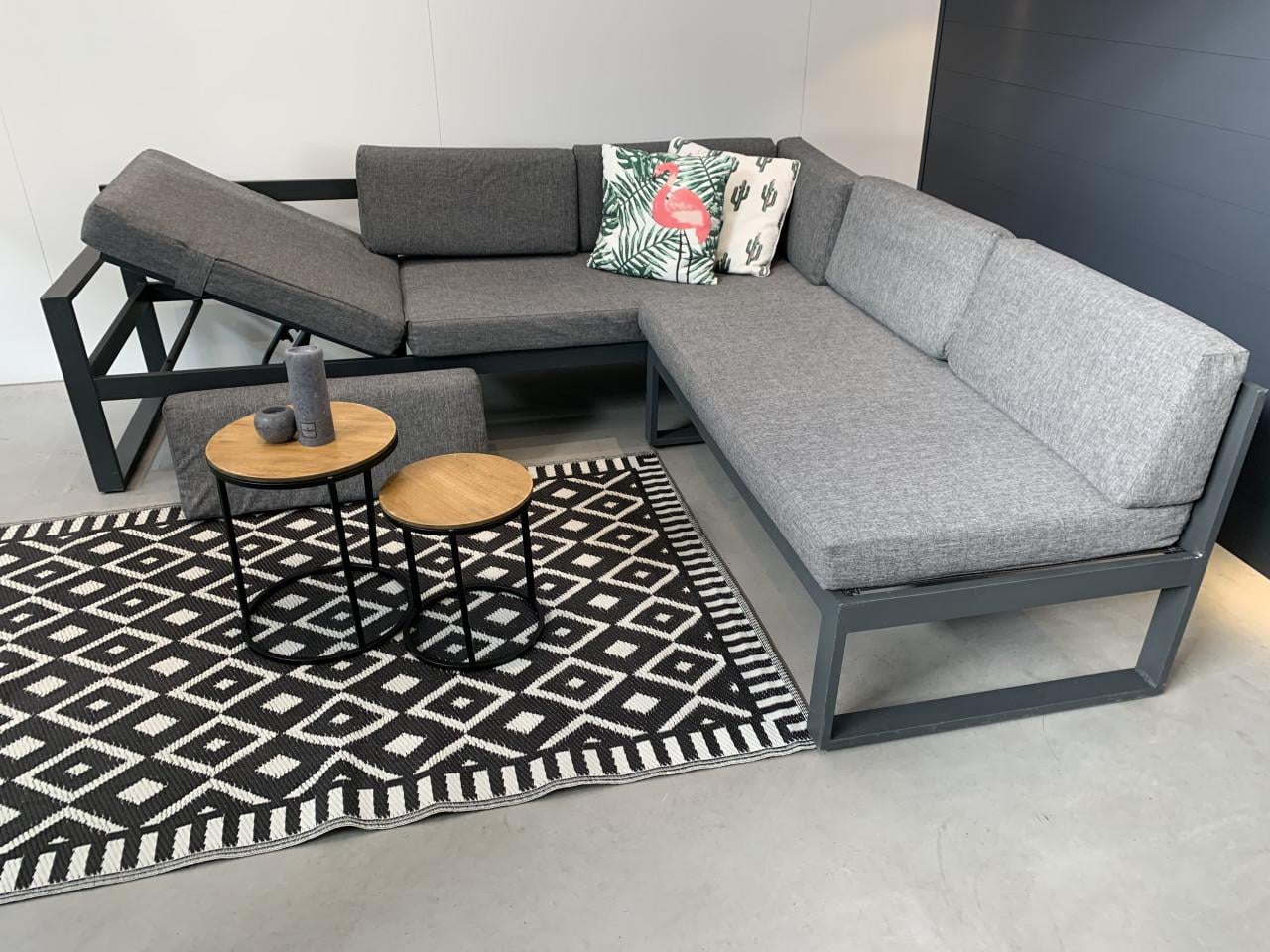 Loungeset aluminium grijs met grijze kussens en tafeltjes.