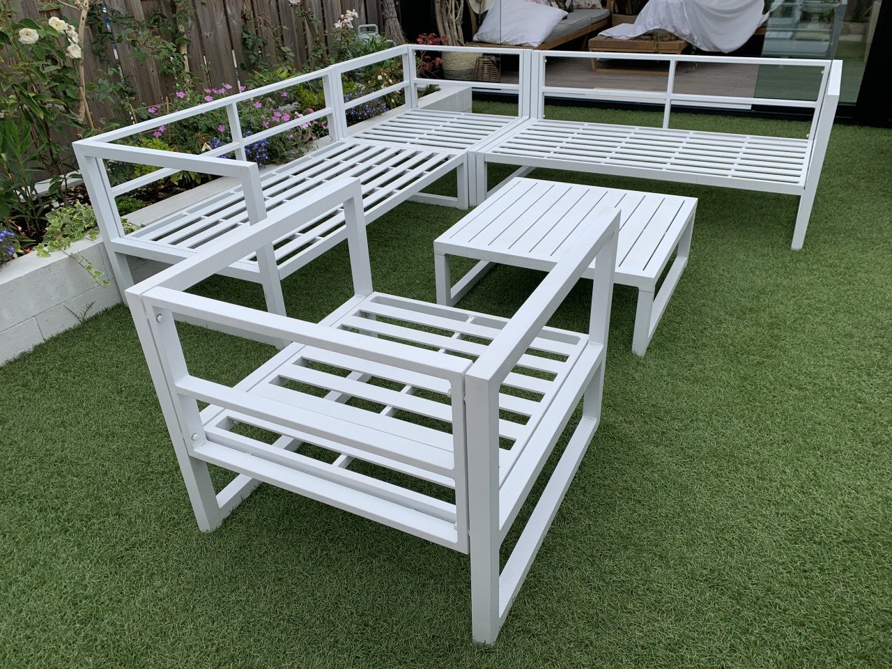 Wit aluminium loungeset met kussens tafel en stoel.