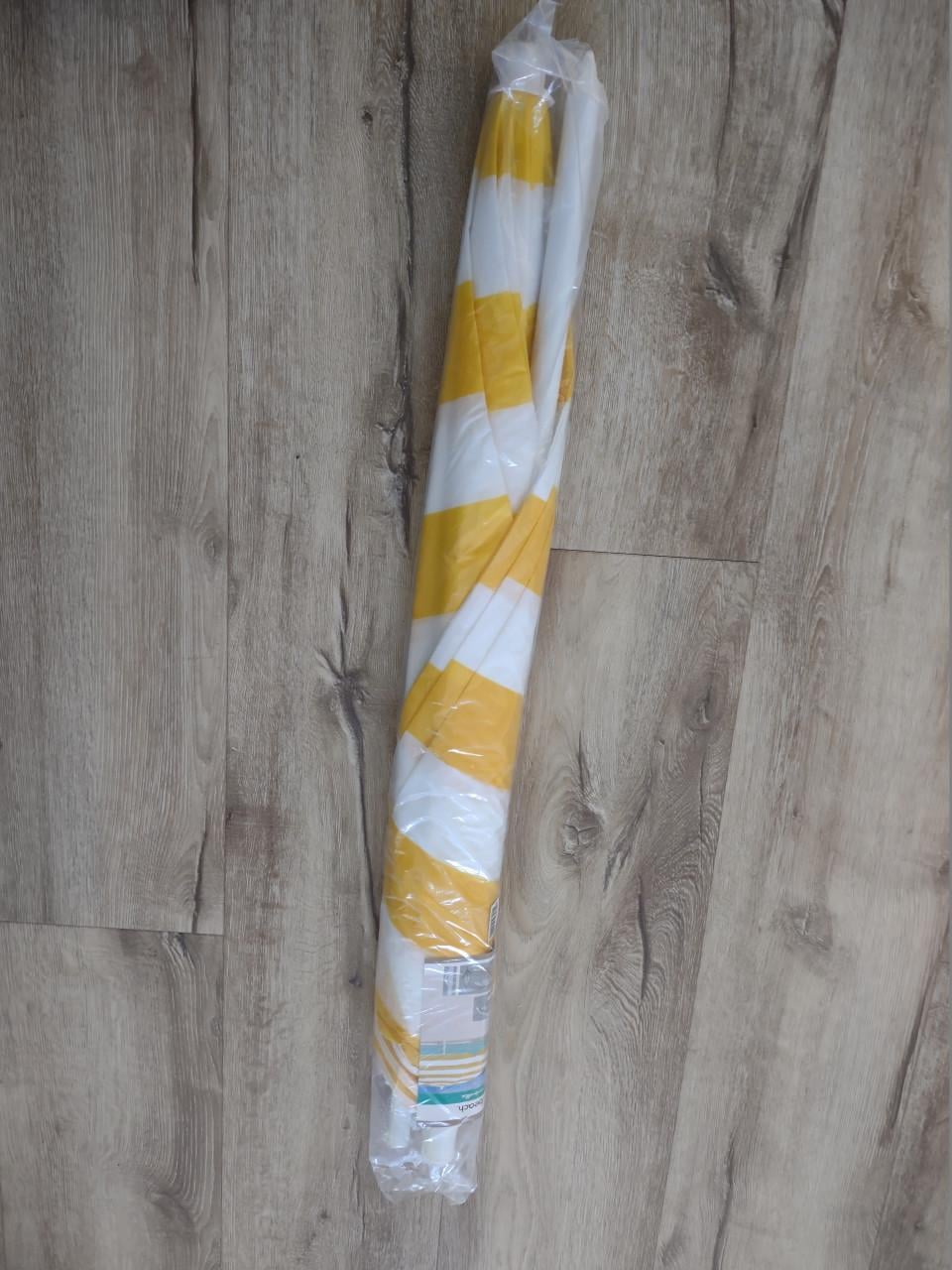 Prachtige nieuwe geel wit gestreepte strandparasol, parasol.