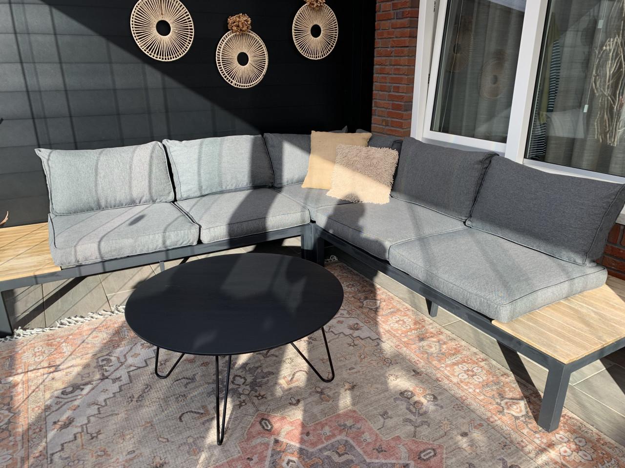 Zwarte loungset met houten plataus, kussens en tafel