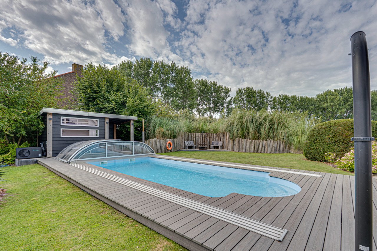 Rietgedekte villa met een overdekt zwembad.