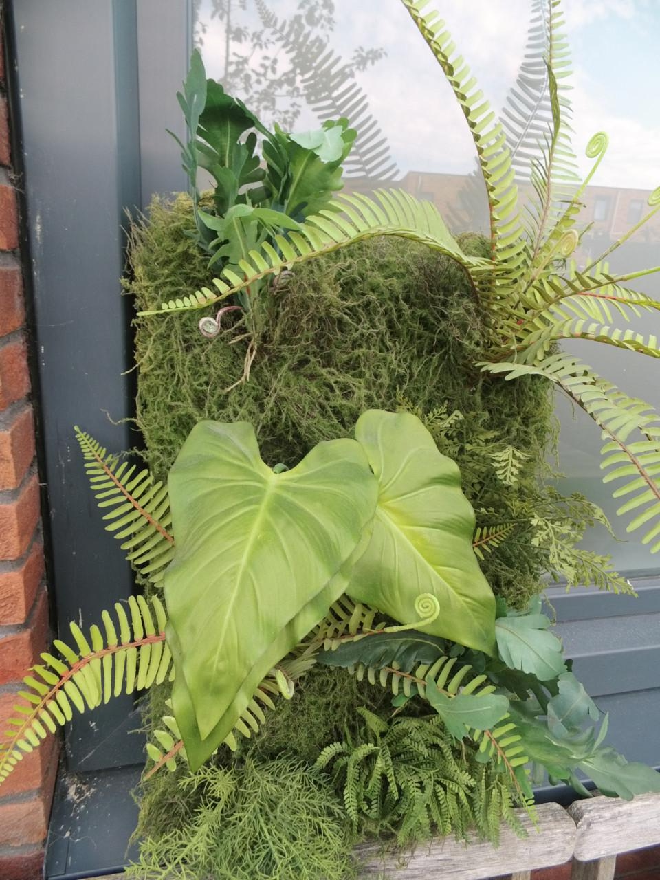Wanddecoratie met kunstplanten.