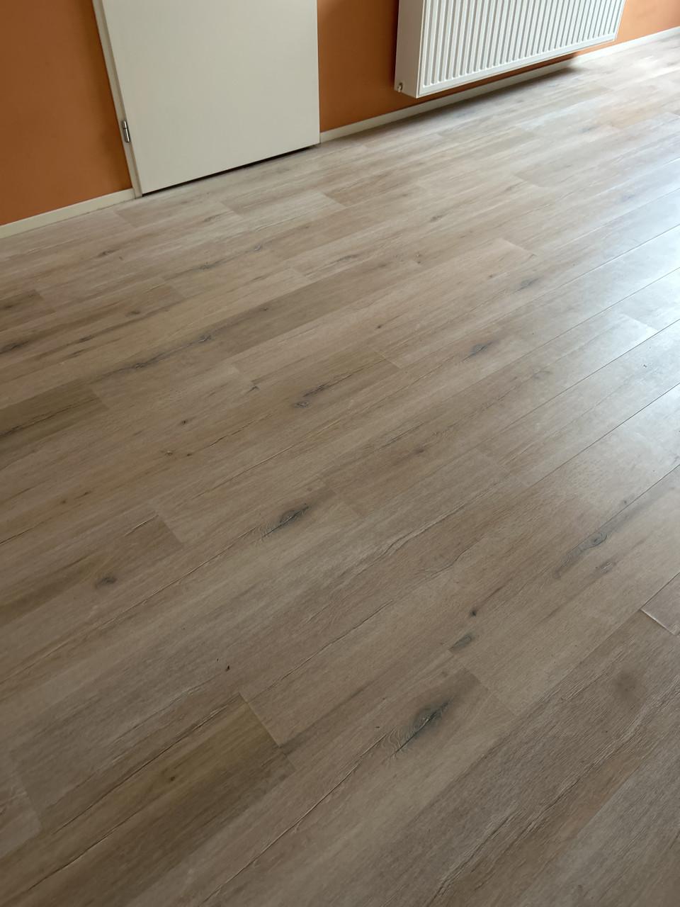 Laminaat licht met grijstinten v groef plinten en ondervloer