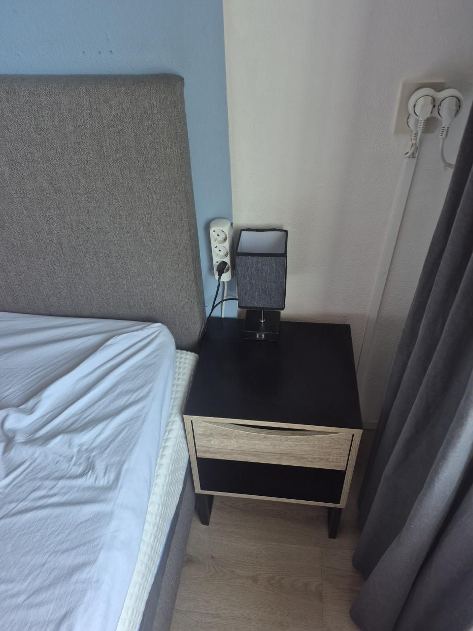 2 zwart houten nachtkastjes.
