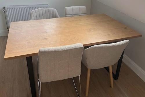 Licht bruine eettafel met 4 beige stoelen