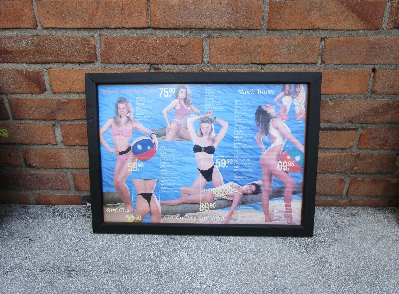 Ingelijste folder van dames badkleding achterontspiegelt glas.