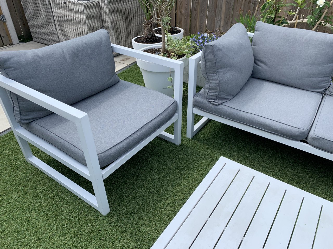 Wit aluminium loungeset met kussens tafel en stoel.