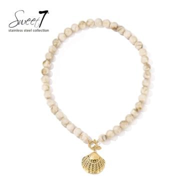 Halsketting met beige kralen en goudkleurige schelp hanger