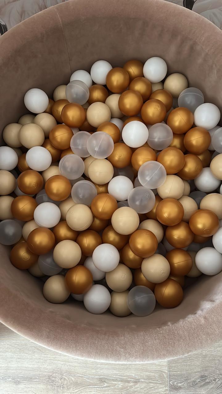 Roze fluwelen ballenbak met gouden en witte ballen