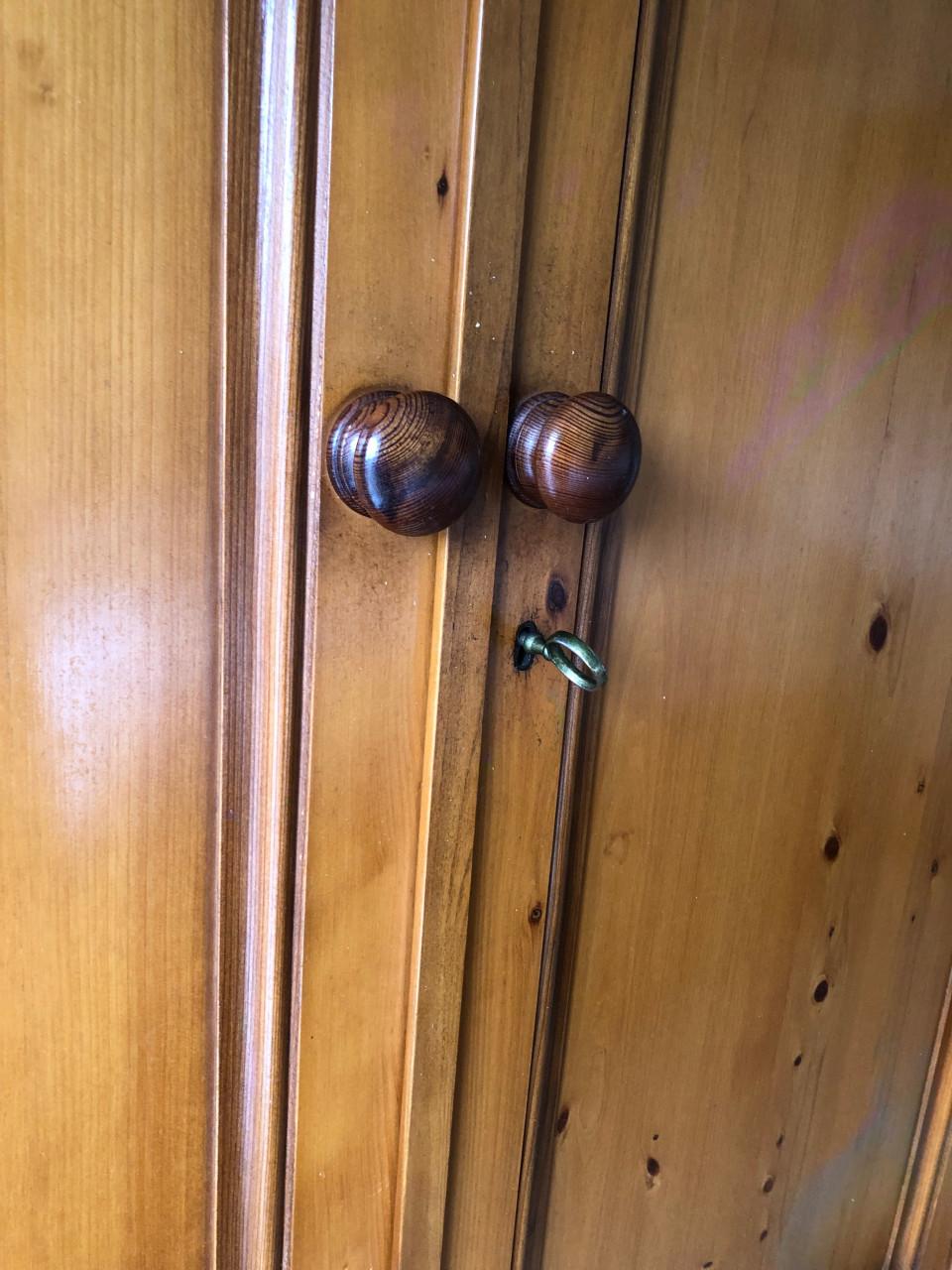 Grote houten kledingkast met deuren en lades.