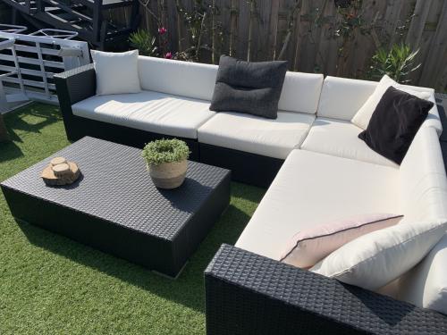 Wicker loungeset zwart met kussens en tafel.
