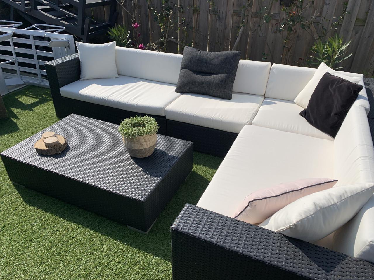 Wicker loungeset zwart met kussens en tafel.