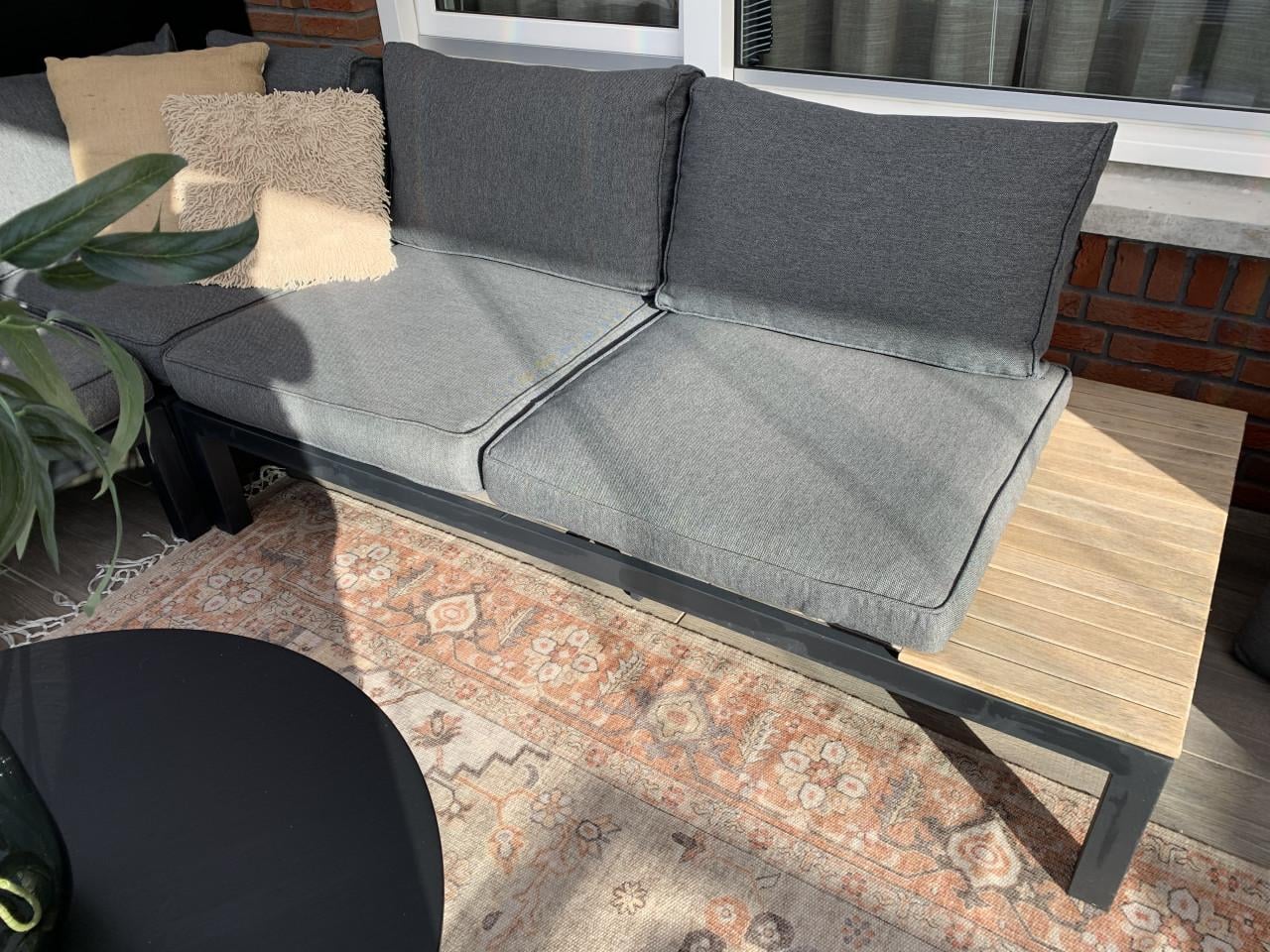 Zwarte loungset met houten plataus, kussens en tafel