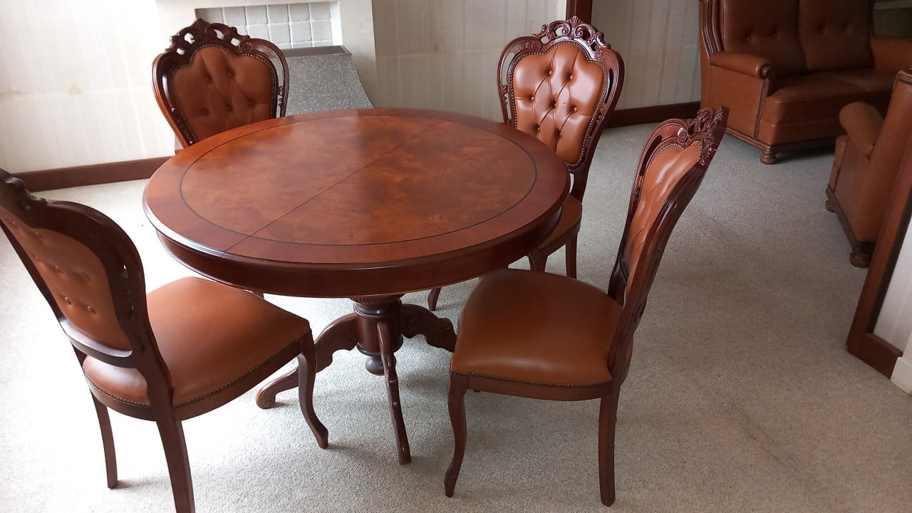 Uitschuifbare tafel met vier bijpassende lederen stoelen