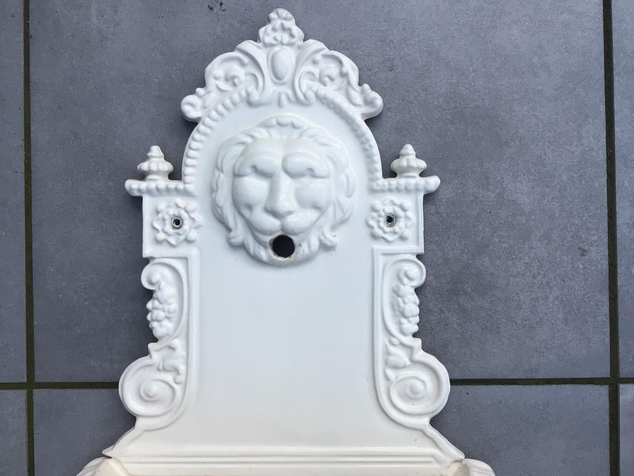 Gietijzeren wandlantaarn en fontein