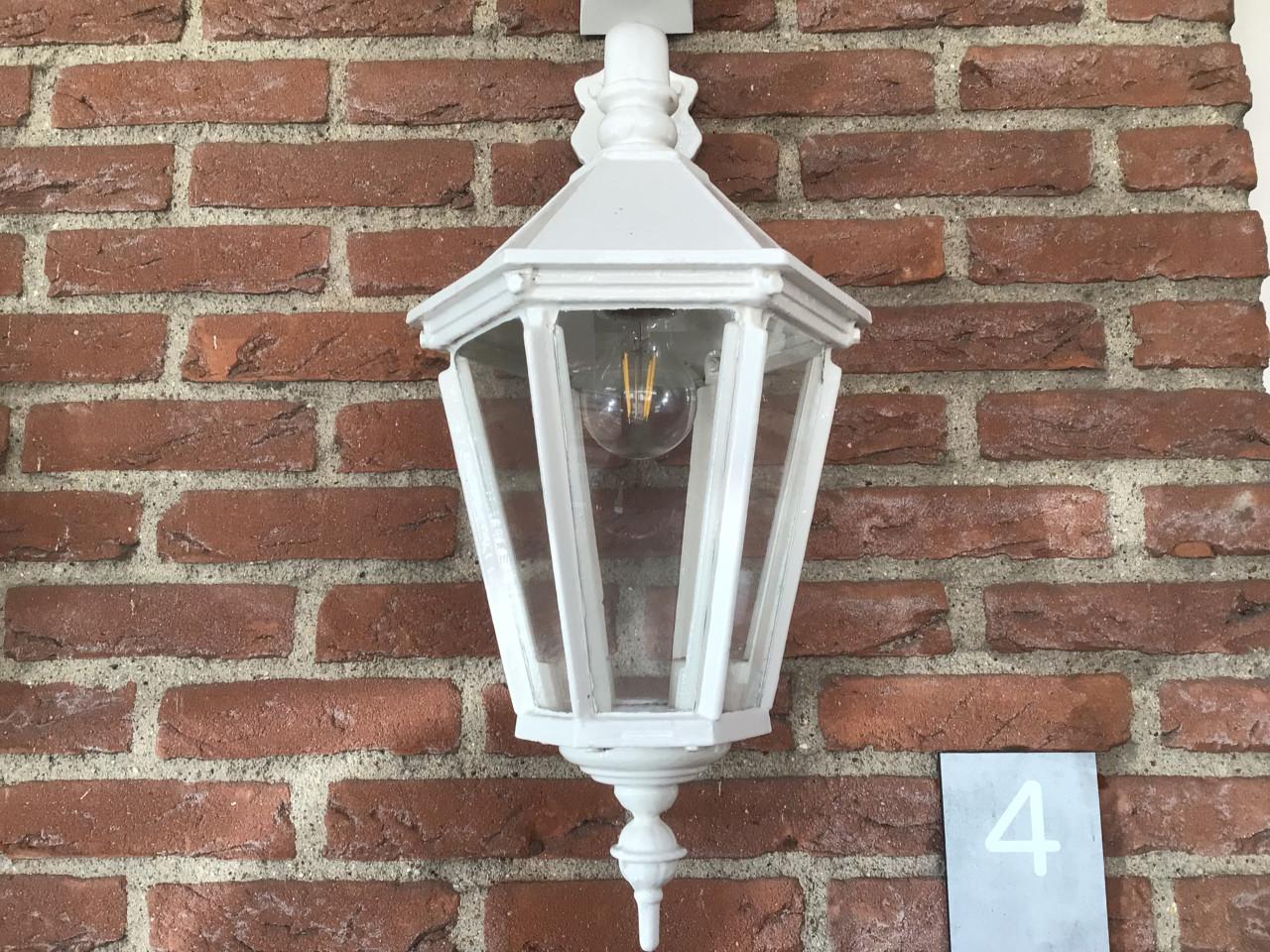 Gietijzeren wandlantaarn en fontein