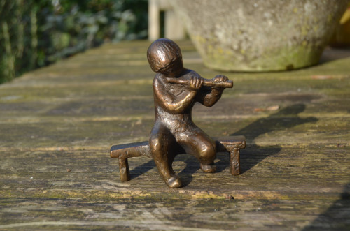 Bronzen beeldje fluitspelend menneke op een bankje