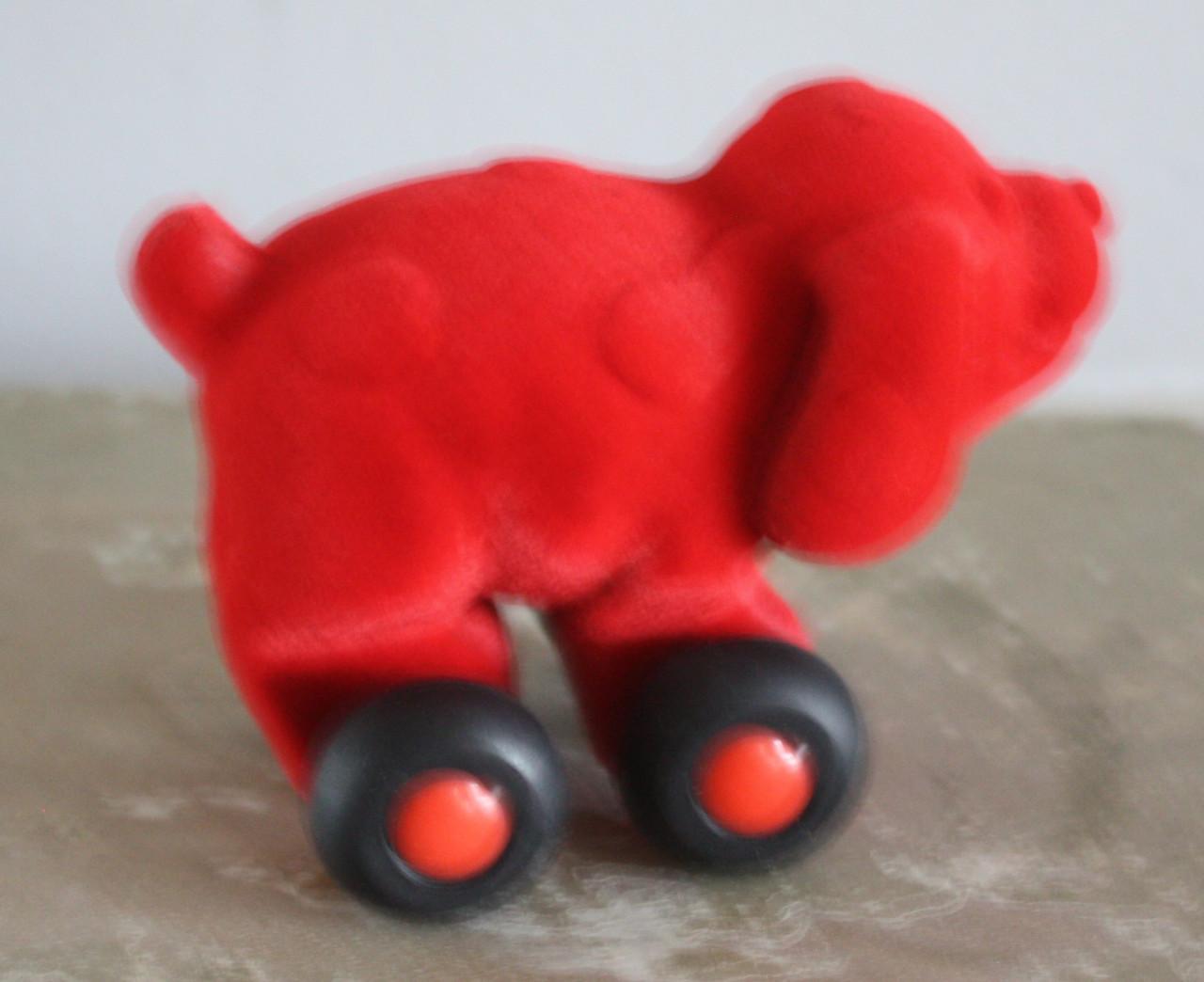 Rood stoffen hondje op wielen