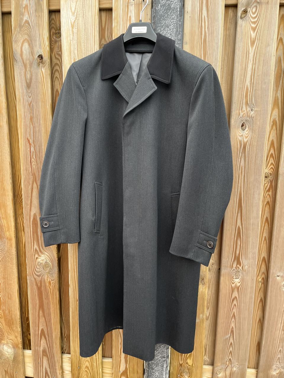 Grijze heren jas met zwarte kraag.