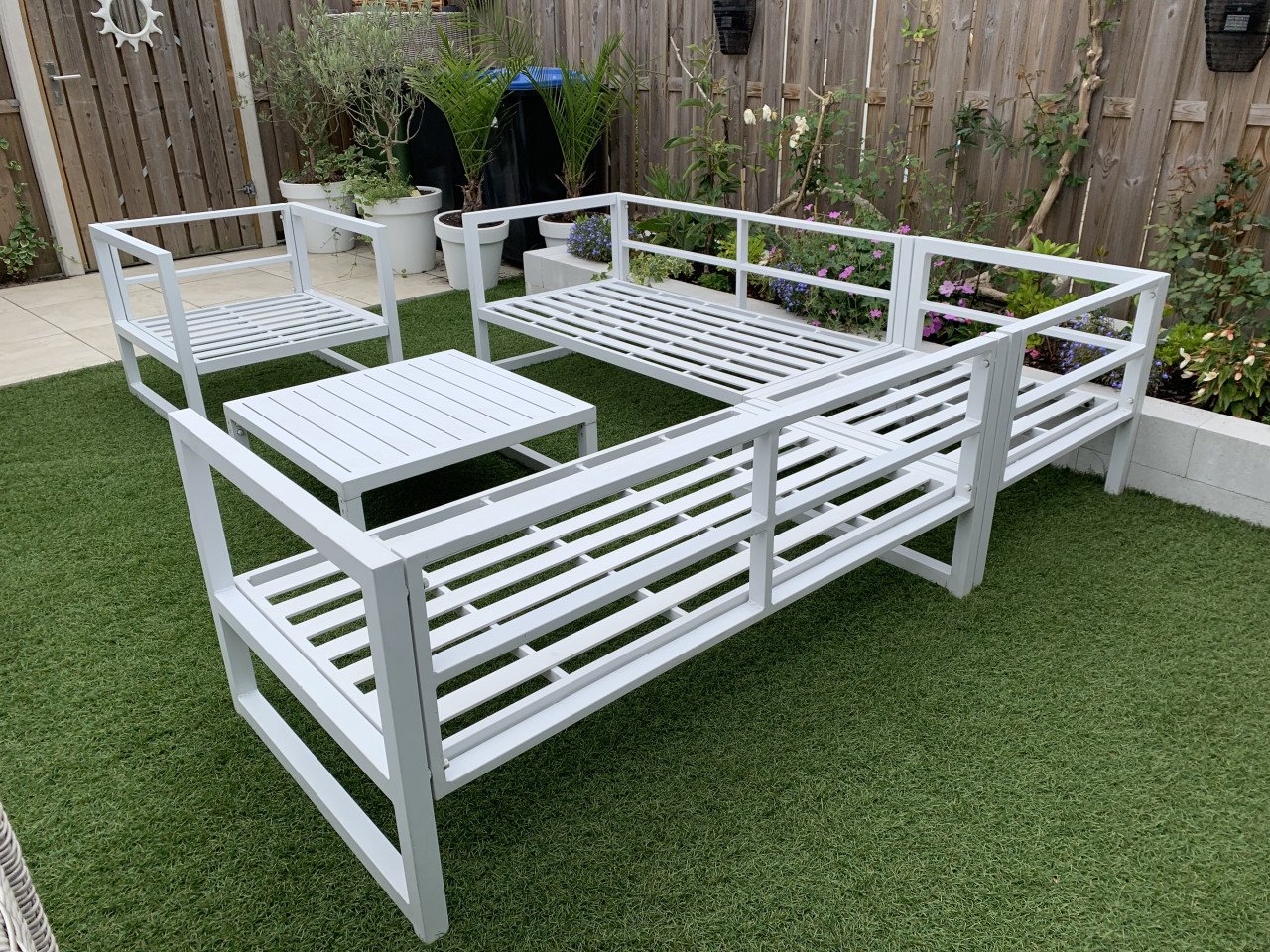 Wit aluminium loungeset met kussens tafel en stoel.