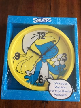Een leuke wandklok met de afbeelding van een Smurfin.   NIEUW IN VERPAKKING