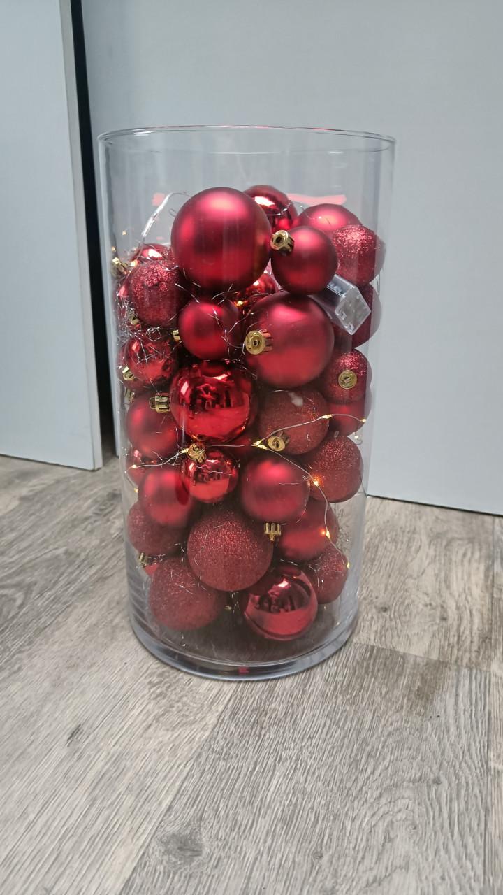 Glazen vaas met rode ballen en verlichting