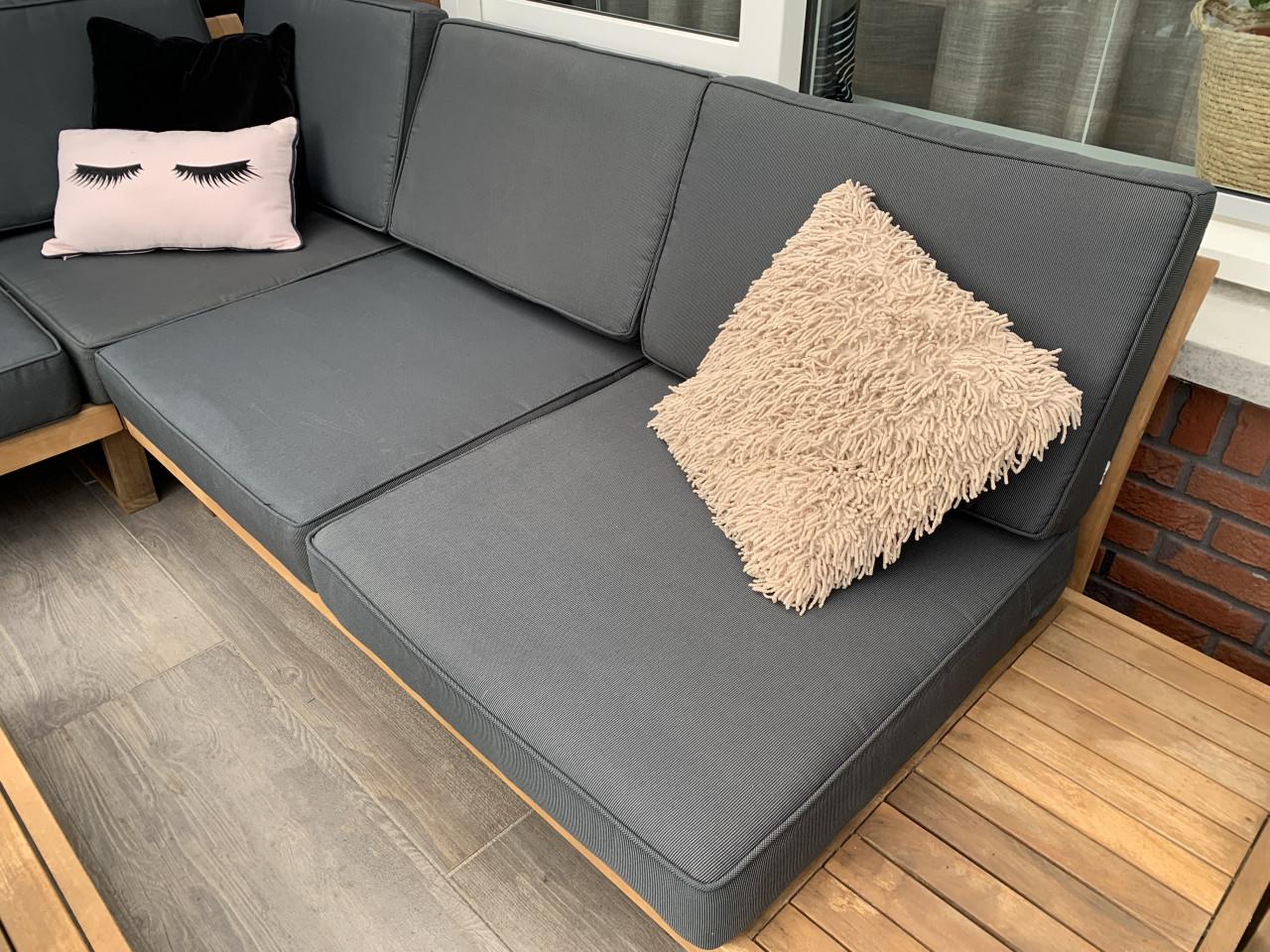 Hardhouten loungeset met kussens en tafel.