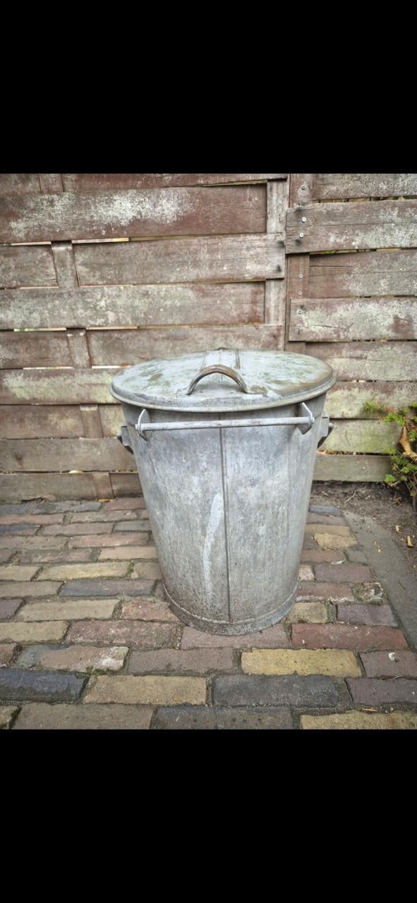 Oude zinken vuilnisbak