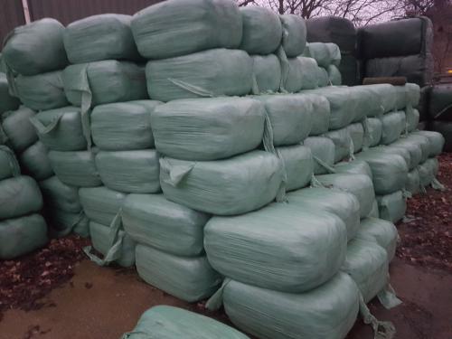 Kleine pakjes gewikkeld hooien enkele grote pakken hooi