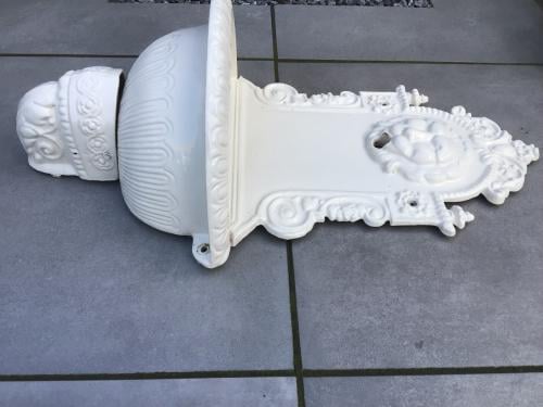 Gietijzeren muurfontein en lantaarn