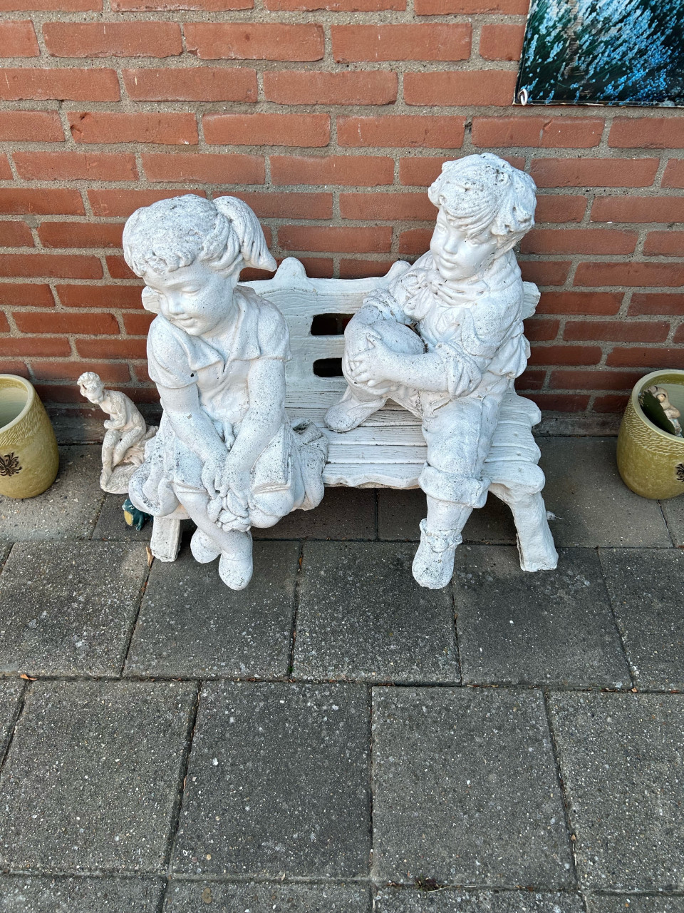 Betonnen beeldje op bankje