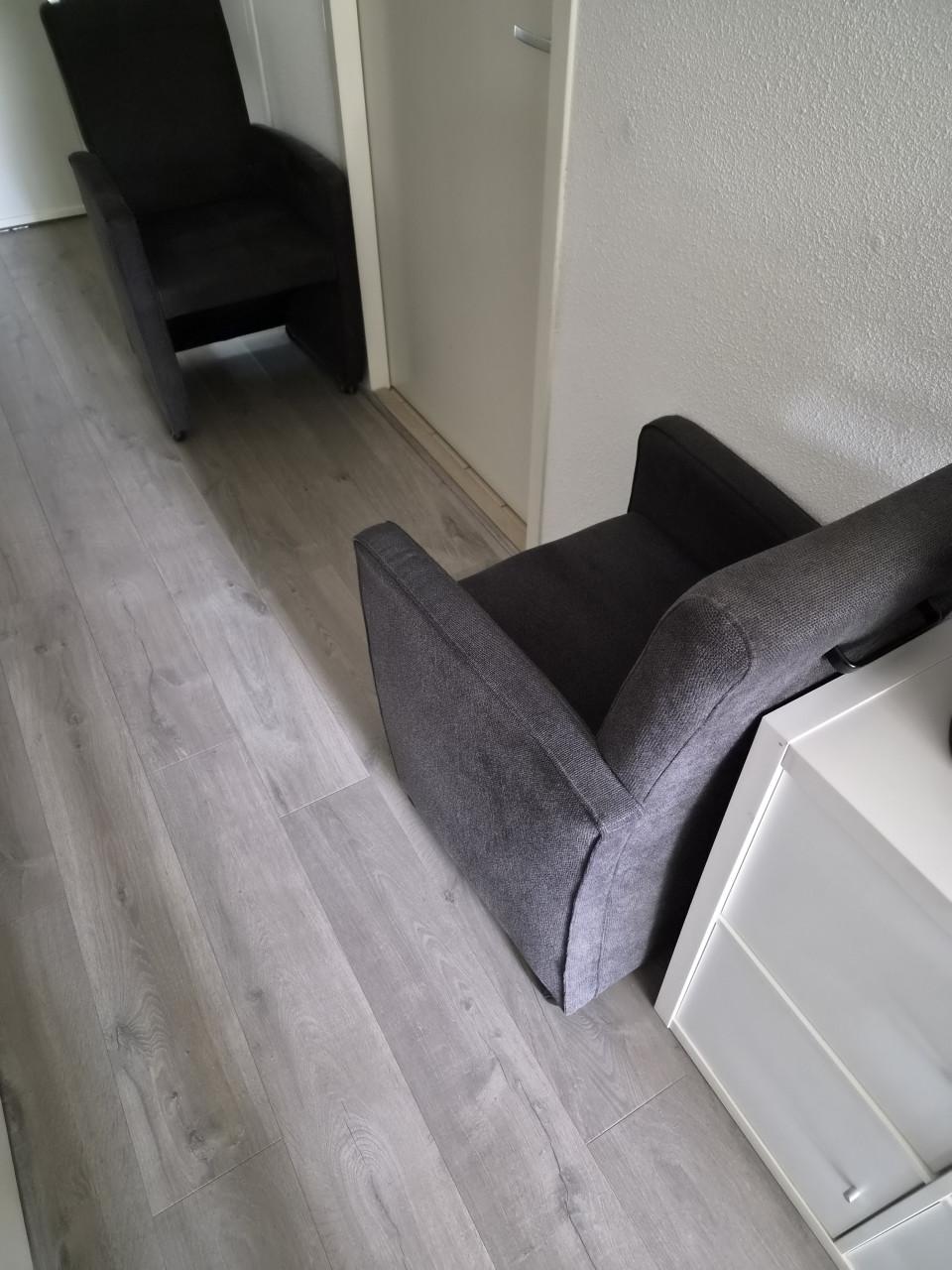 4 grijze stoffen eetkamerstoelen.