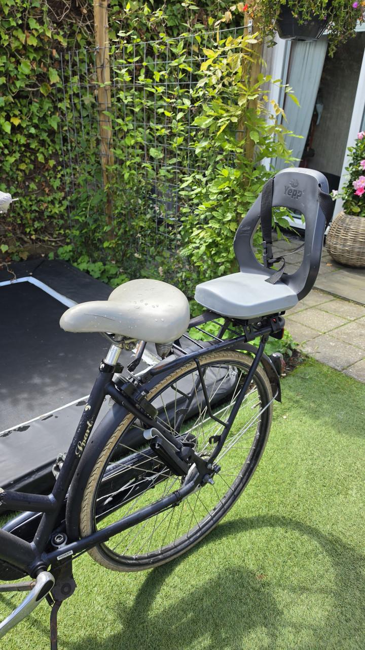Batavus damesfiets met kinderzitje achterop.