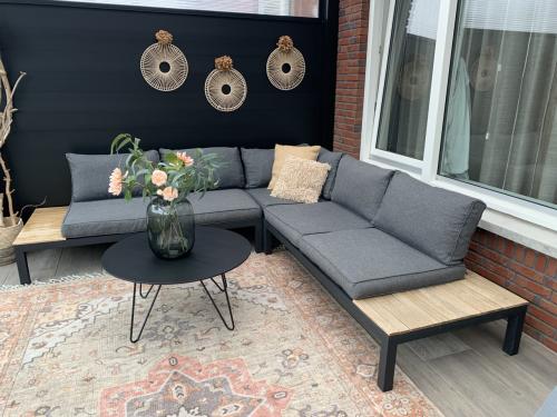 Zwarte loungset met houten plataus, kussens en tafel