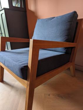 Moderne design fauteuil van massief hout met donkerblauwe kussens