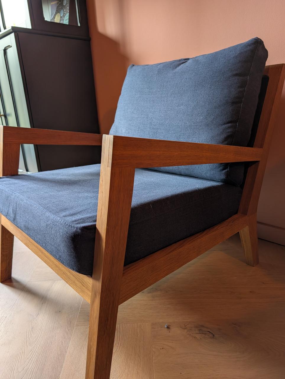 Moderne design fauteuil van massief hout met donkerblauwe kussens