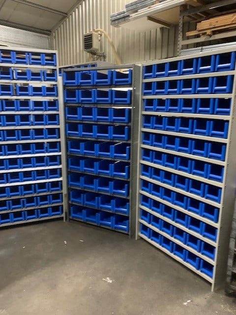 Diverse stellingen gevuld met kunststof magazijnbakjes