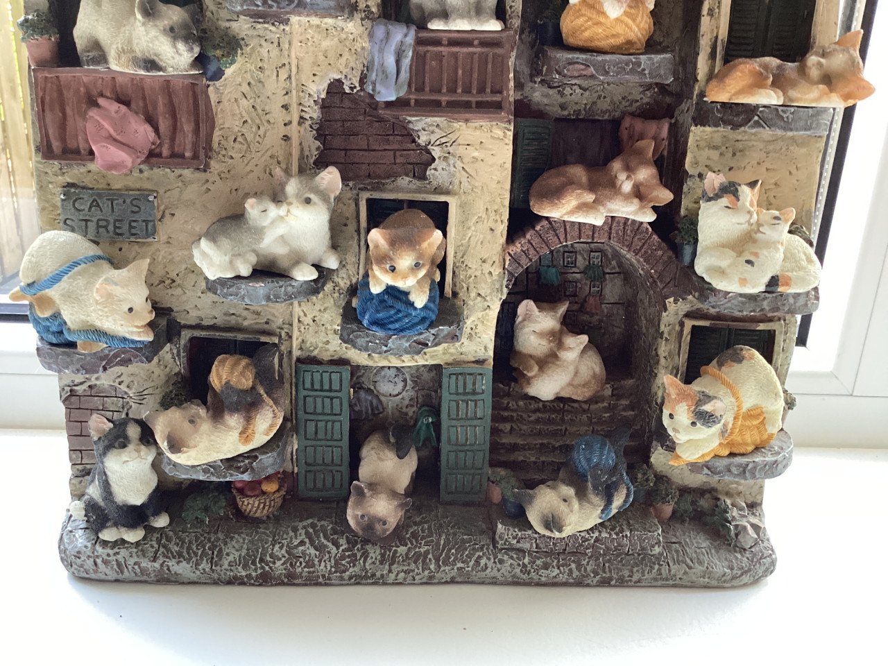 Stenen kattenluik met katten beeldjes