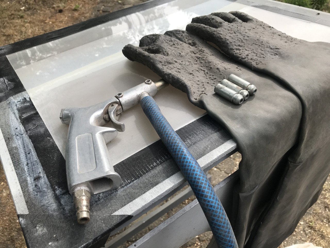 Straalcabine met pistool, handschoenen en grid