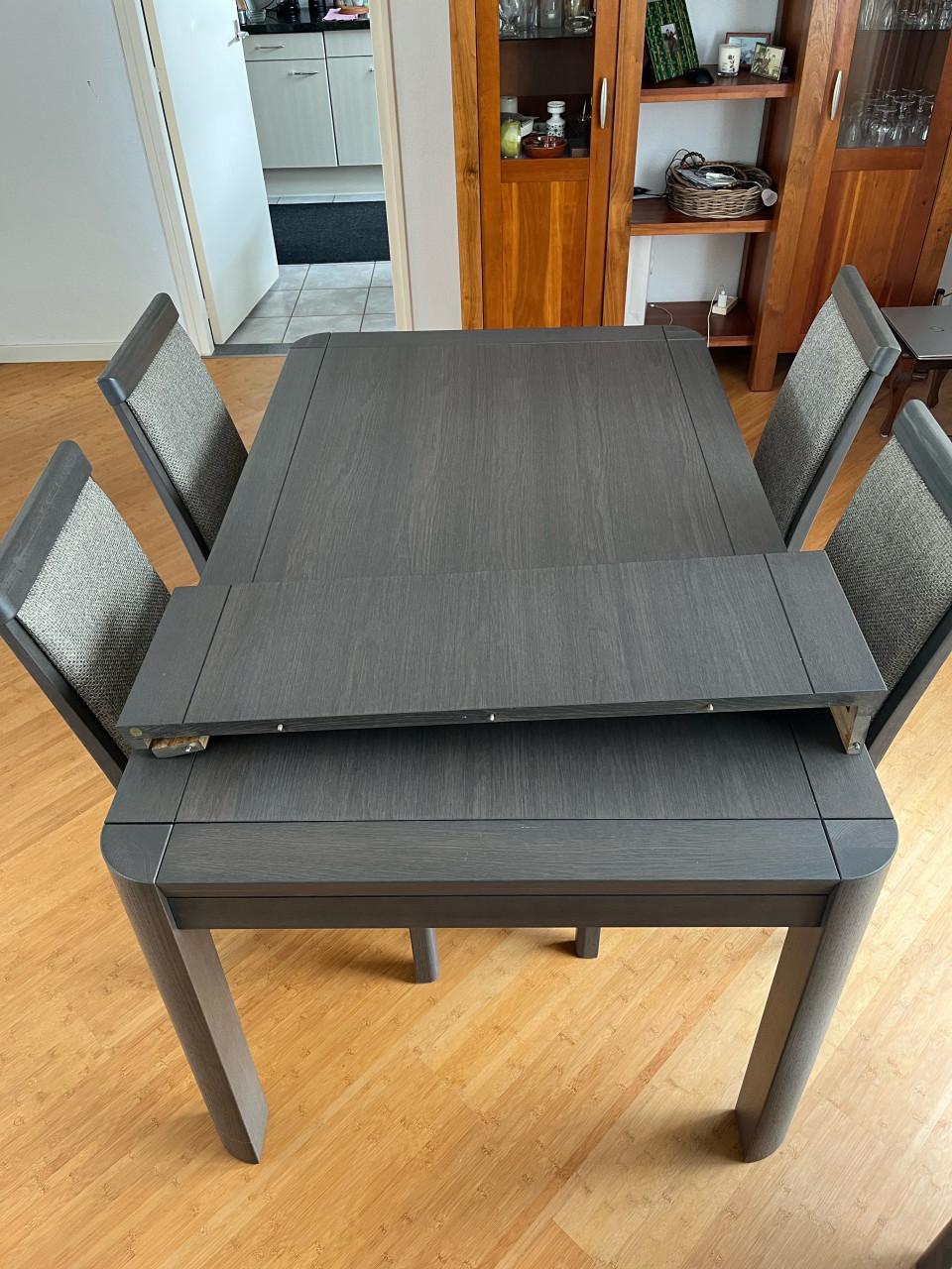 Eettafel met verstelbaar blad en zes stoelen.
