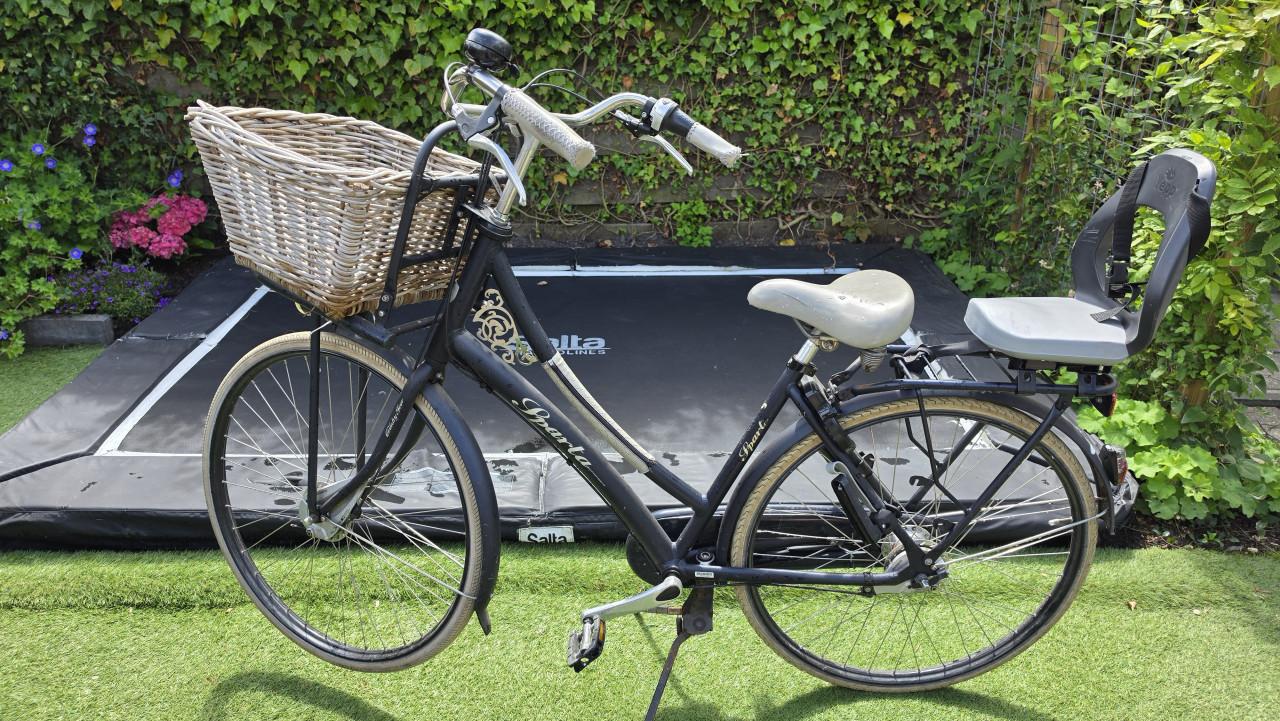 Batavus damesfiets met kinderzitje achterop.