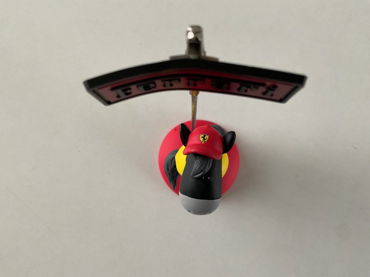 Ferrari houdertje en een boekje met foto’s.    Hoog: 12 cm.