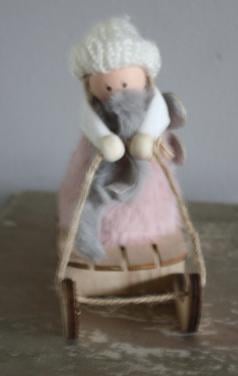 Roze stoffen popje op houten slee