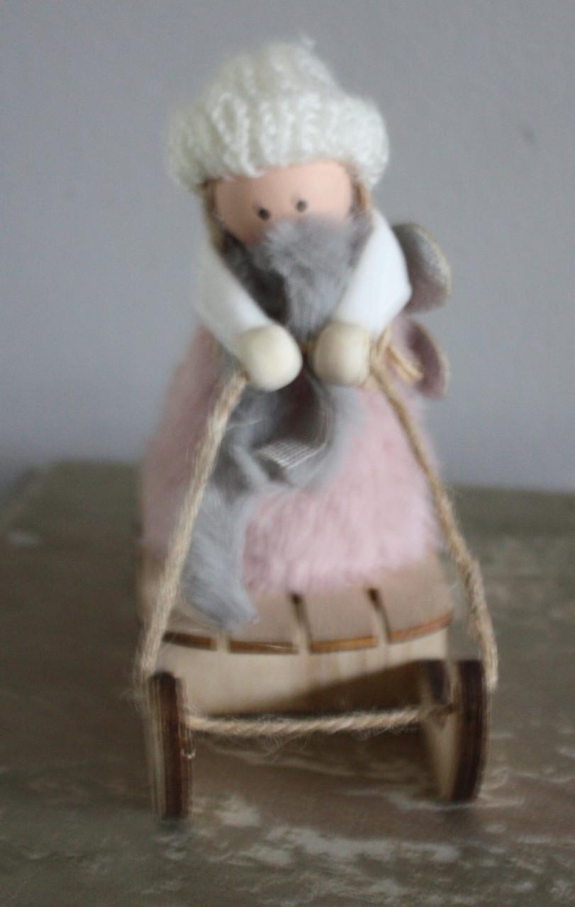 Roze stoffen popje op houten slee