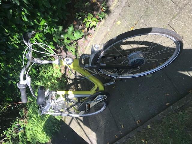 Elektrische Fiets groengelig met kapotte motor en nieuwe oplader