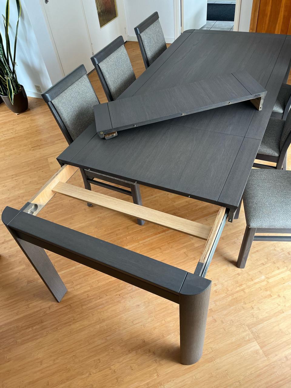 Eettafel met verstelbaar blad en zes stoelen.