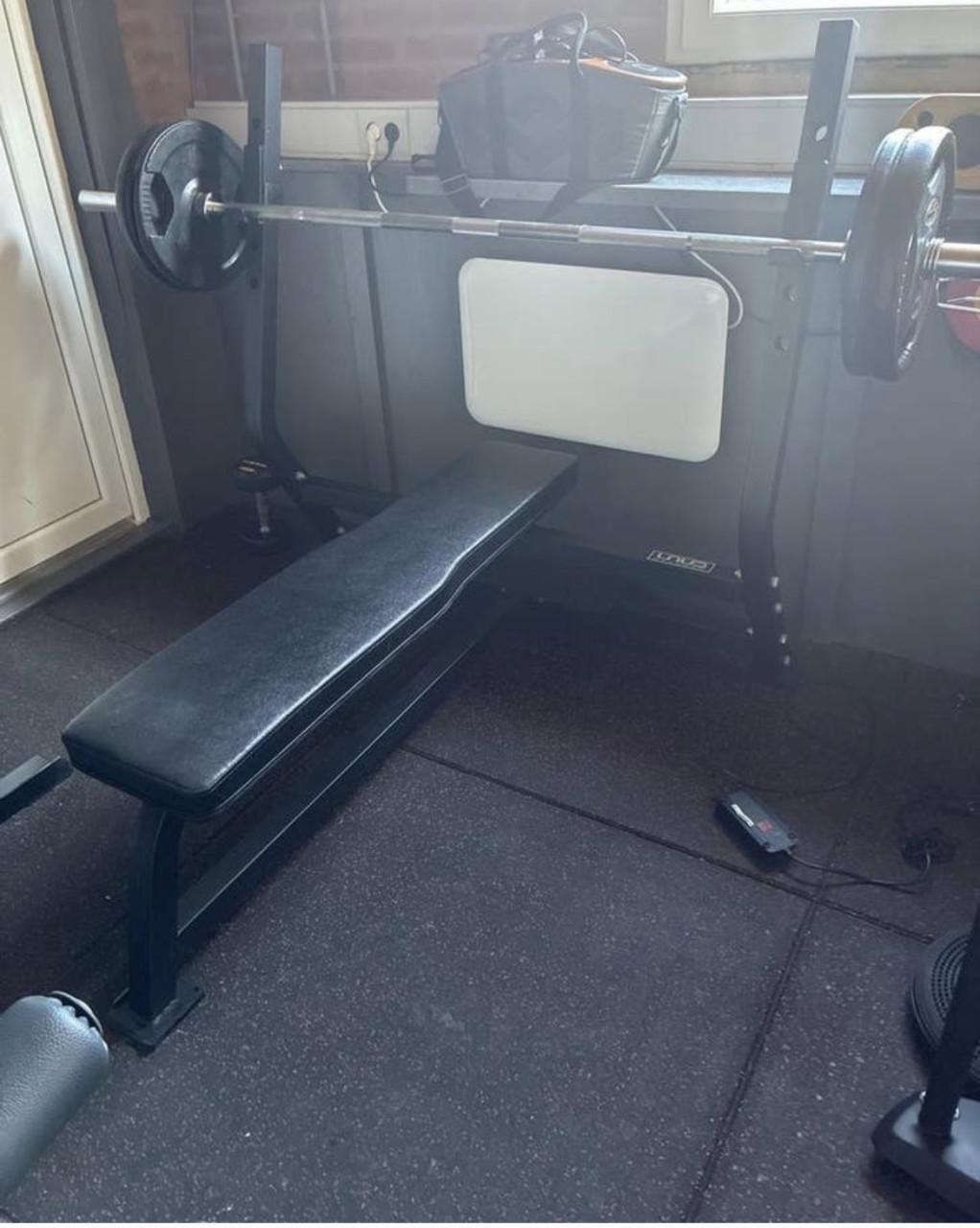 Te koop fitnessbank met halterstang en gewichten